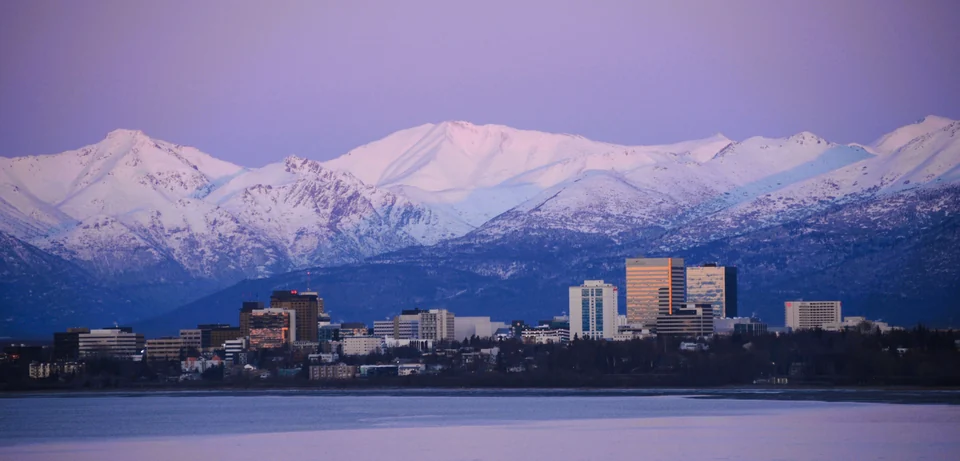 Anchorage skyline and snow-covered Chugach Mountains at sunset